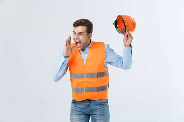 Angry engineer with angry face emotion shouting at someone raising his both hands, isolated on a white background. - Фото, изображение