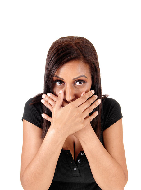 Een bang jonge vrouw met cabines overhandigt haar mond lookin - Foto, afbeelding