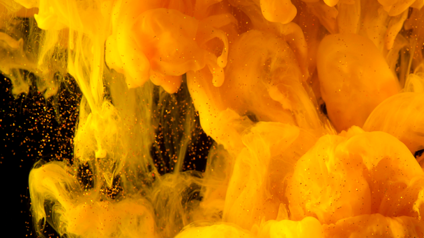 Altın glitter mürekkep siyah su altında portakallı. Soyut bulut formasyonları oluşturma suya tepki sarı boya renk. Geçişler, projelere eklendi olarak kullanılabilir - Video, Çekim