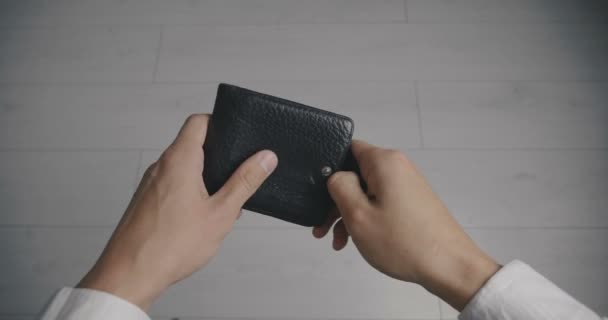 お金なしで空の革財布を保持する人の手のクローズアップ。貧困の概念 - 映像、動画