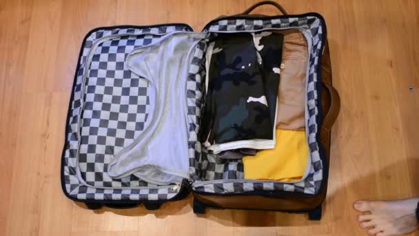 Top view matkustaa käsite mies lajittelu ja pakkaus hänen vaatteensa matkalaukkuun
 - Materiaali, video