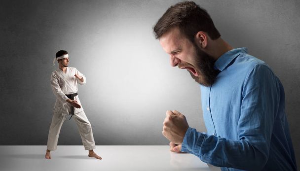 Reuze hipster man schreeuwen op een man kleine karate - Foto, afbeelding