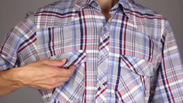 człowiek w plaid shirt otwiera kieszeń, wyjmuje nowej prezerwatywy i sprawia, że gest kciuk, pojęcie relacje oparte na zaufaniu i odpowiedzialności, szare tło  - Materiał filmowy, wideo