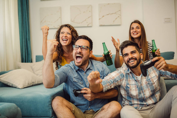 Group of friends having fun and play video games together. - Foto, afbeelding