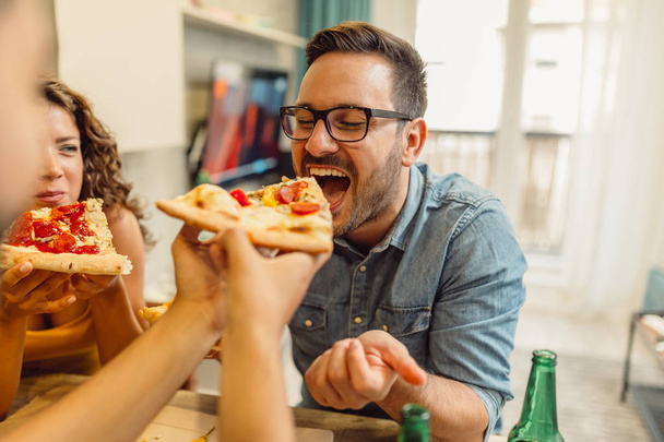 Ryhmä ystäviä hauskaa kotona tuoretta olutta ja maukasta pizzaa
 - Valokuva, kuva