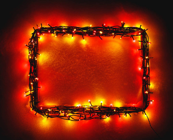 Christmas lights frame on snow background, red color - Photo, Image