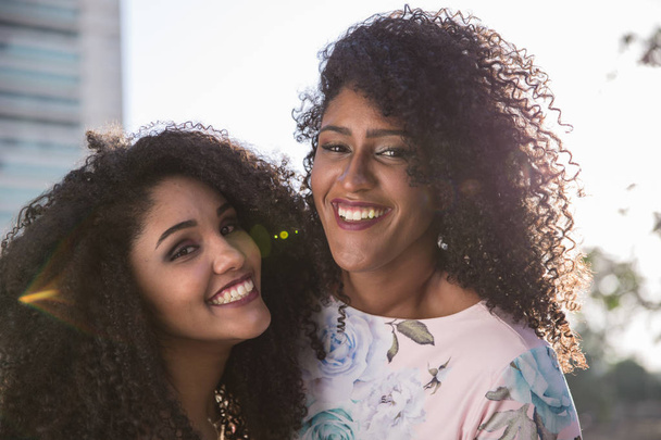 zwei junge Afro-Girls, die zusammen Spaß haben, Freude, Positives, Liebe, Freundschaft, Schwestern. glückliches Treffen zweier Freunde, die sich umarmen. Lesbisches Konzept. - Foto, Bild