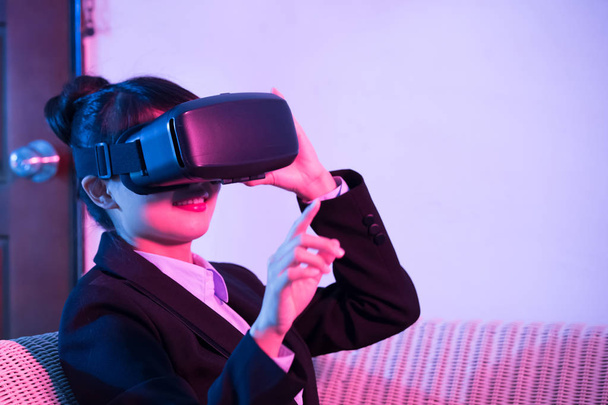 businesswoman  on sofa  wearing virtual reality headset at home - Foto, imagen