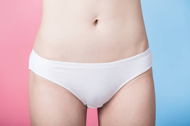woman with laser hair removal bikini line concept on the blue and pink background - Foto, imagen
