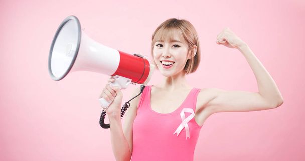 woman with megaphone  showing  strong arm with prevention breast cancer concept - Valokuva, kuva