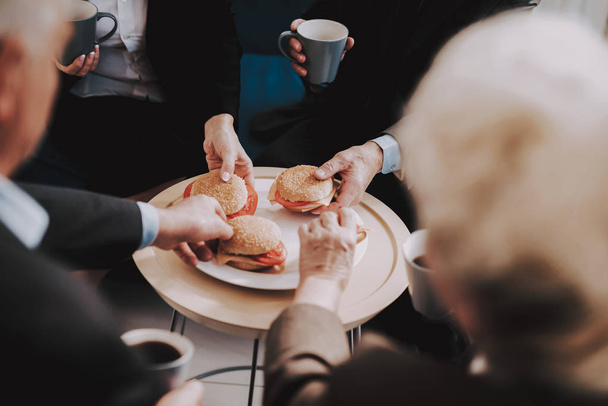 Старі пари їдять бургери з кавою в аеропорту
. - Фото, зображення