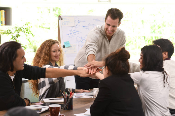 Grupo de empresários empilhando as mãos em conjunto em acordo em uma reunião no escritório
 - Foto, Imagem