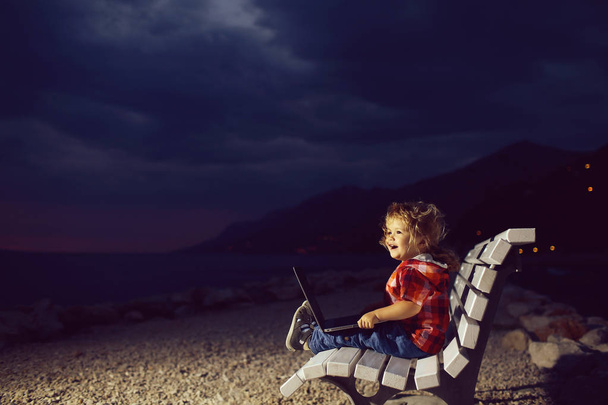 cute boy with laptop on beach - 写真・画像