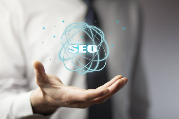 Business man holding SEO icon  - Foto, afbeelding