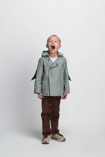 niño gritando sobre fondo blanco, rodaje en el estudio
 - Foto, Imagen