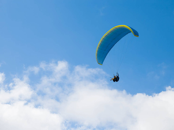 パラグライダー ファイナル アプローチ、着陸する前に青い曇り空を背景表示 - 写真・画像