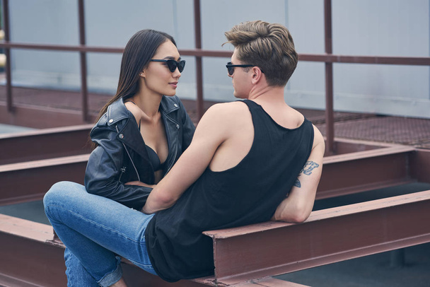 multiethnic stylish sexy couple in sunglasses looking at each other - Foto, afbeelding