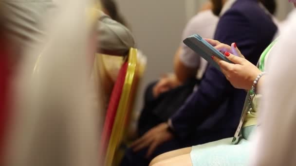 Mensen zitten op handelsconferentie, man met smartphone in handen, close-up - Video