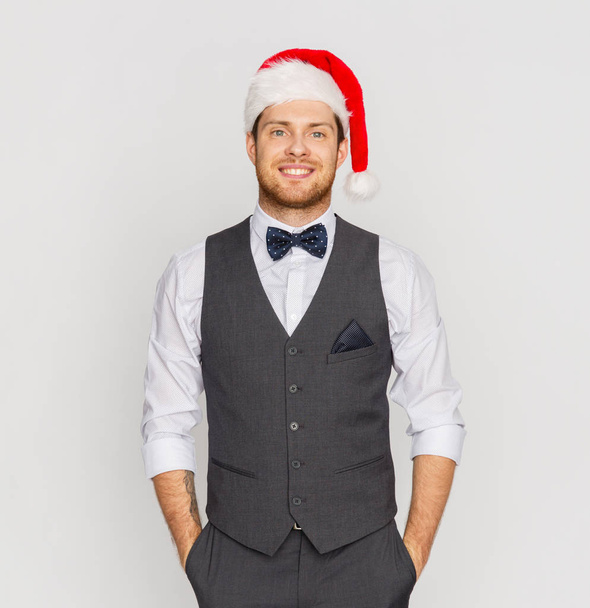 happy man in santa hat and suit at christmas - Foto, imagen