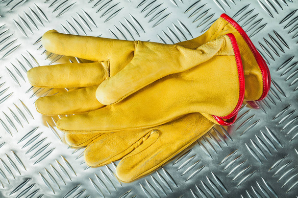 Leather protective gloves on corrugated metal texture. - Fotoğraf, Görsel