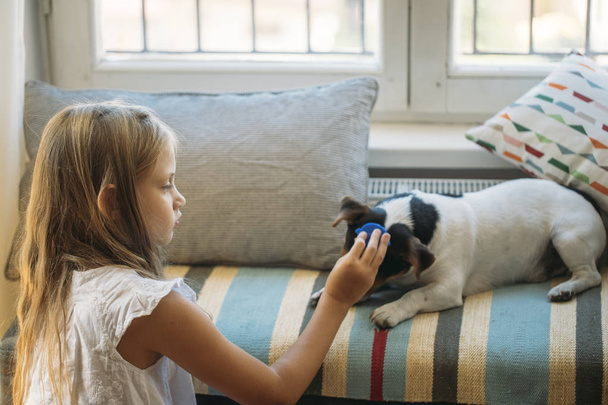 Szép szőke lány játszik vele kutya kisállat otthon. - Fotó, kép