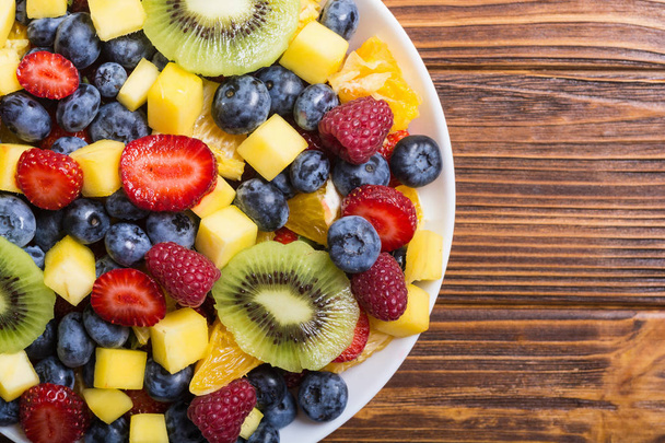 Frisse salade van fruit en bessen. Gezonde vitamine voedsel achtergrond . - Foto, afbeelding