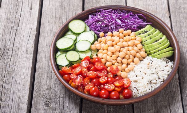 Healthy vegetarian salad with avocado, cucumber, cabbage, chickpea and tomatoes . Vegan food - Foto, afbeelding