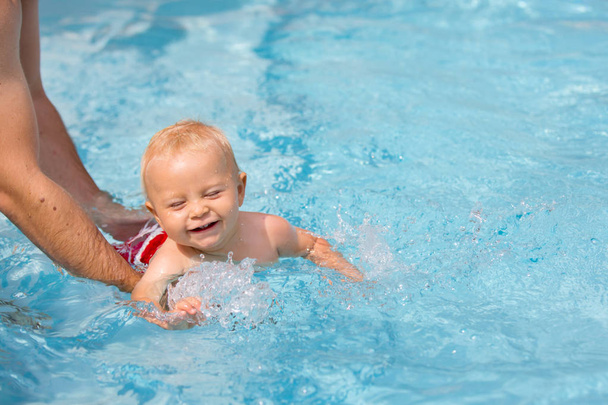 Jeux dans la piscine extérieure. Famille en vacances. Spa Resort
 - Photo, image