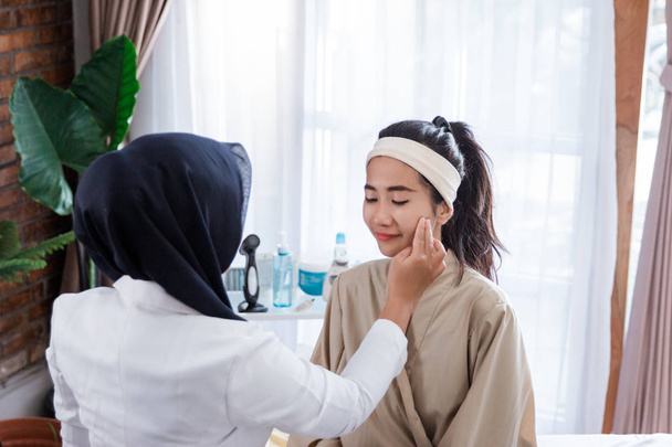 Cosmetic doctor examining female client  - Zdjęcie, obraz