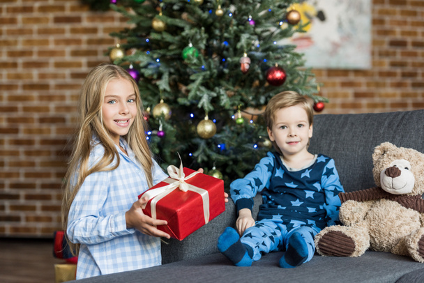 カメラで笑顔のクリスマス プレゼントとかわいい幸せな子供たち  - 写真・画像