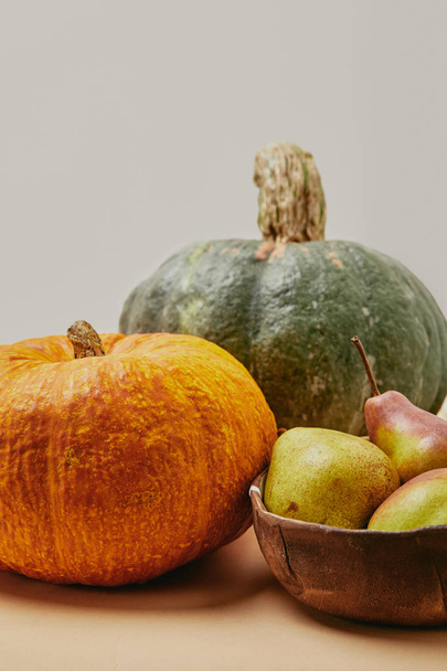close up of autumnal harvest with pumpkins and ripe yummy pears on table - Фото, зображення