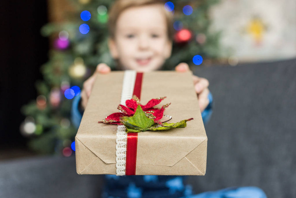 close-up view of adorable happy child holding christmas gift - 写真・画像