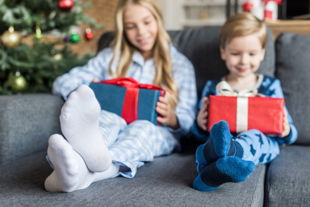 adorable happy kids in pajamas holding gift boxes at christmas time - Foto, Imagen
