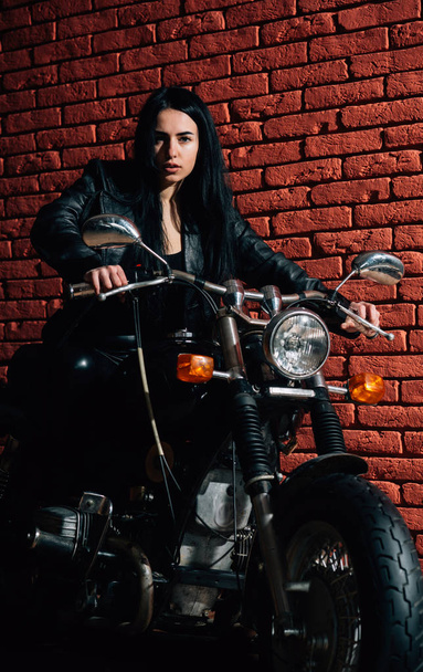 riding motorcycle. sexy woman riding motorcycle. woman biker riding motorcycle. girl riding motorcycle at brick wall. - Фото, изображение