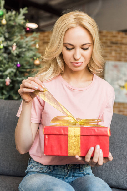 beautiful young woman opening gift box at christmas time - Foto, Imagem