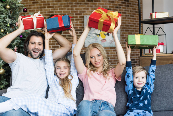 mooie en gelukkige familie bedrijf Kerstcadeaus en lachend op camera - Foto, afbeelding