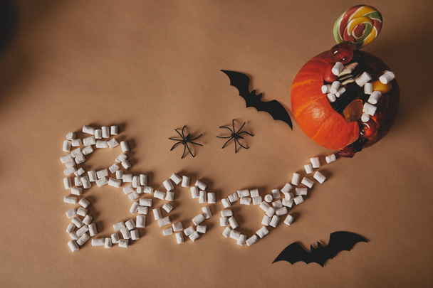 Widok z góry z dyni halloween z papieru nietoperzy i słowo Boo wykonane z pianki na beżowy stół - Zdjęcie, obraz