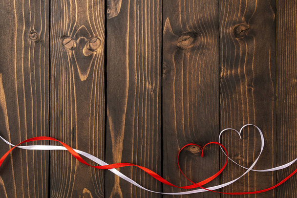 Red and white hearts on a dark wooden background. Background to the day of St. Valentine - Photo, Image