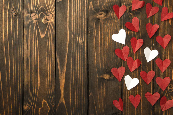 Red and white hearts on a dark wooden background. Background to the day of St. Valentine - Photo, Image
