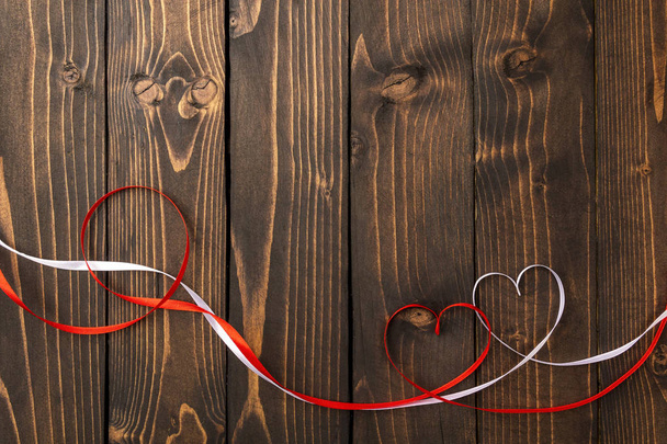 Cuori rossi e bianchi su uno sfondo di legno scuro. Sfondo del giorno di S. Valentino
 - Foto, immagini
