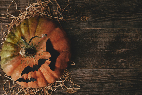 top view of pumpkin and paper bats on wooden table, halloween concept  - Foto, Bild
