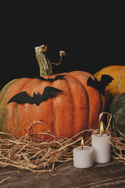pumpkins, candles and paper bats on table, halloween concept - Foto, Imagem