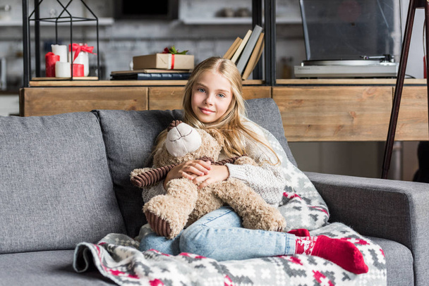 beautiful happy child hugging teddy bear and smiling at camera - Foto, afbeelding