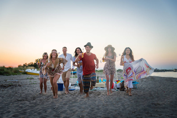 Feliz grupo de amigos celebrando y divirtiéndose en la playa - Jóvenes en vacaciones de verano
 - Foto, imagen