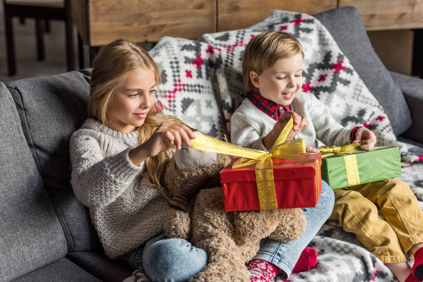 adorable happy children opening christmas presents at home  - Foto, Imagem