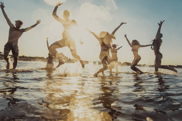 Group of friends having fun at the sea - Happy young people on a summer vacation at the beach - Foto, Bild