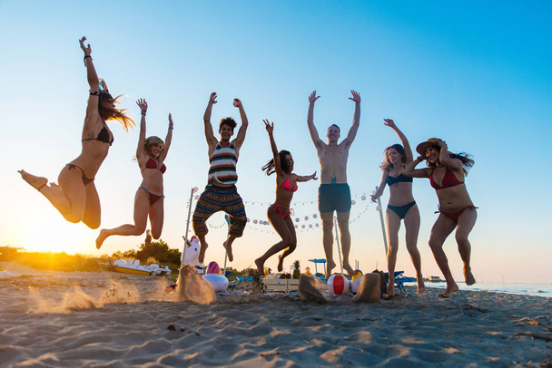 Feliz grupo de amigos celebrando y divirtiéndose en la playa - Jóvenes en vacaciones de verano
 - Foto, Imagen