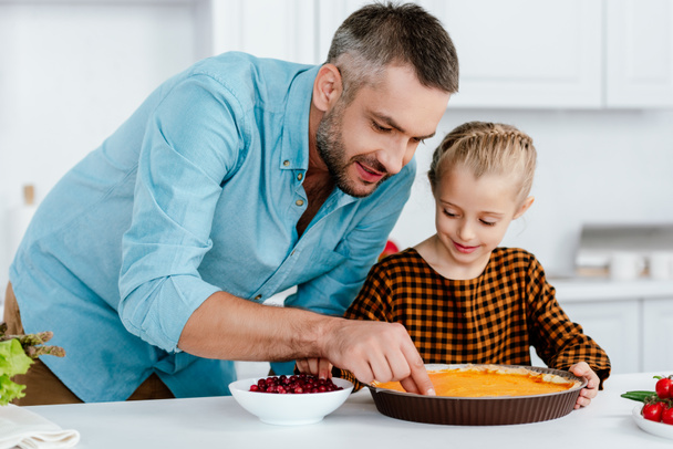 felice padre e adorabile piccola figlia decorazione torta di zucca per il giorno del Ringraziamento
 - Foto, immagini