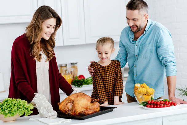 beautiful little child preparing thanksgiving dinner with parents - Photo, Image