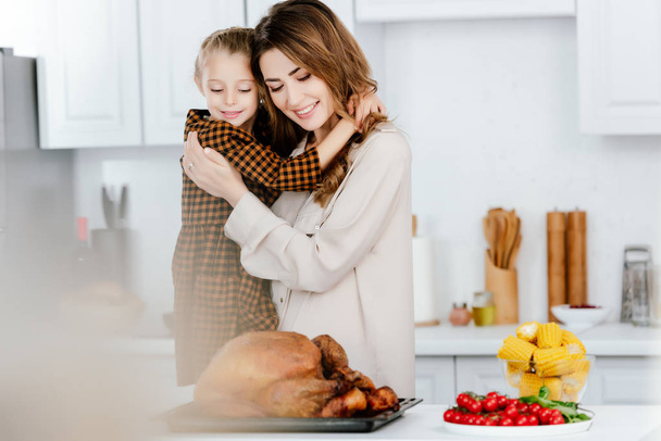 bella giovane madre e figlia abbracciando durante la cottura cena del Ringraziamento insieme
 - Foto, immagini